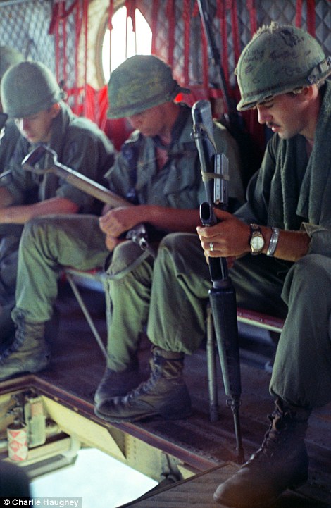 Time out: Soldiers enjoy a brief moment of relaxation as they ride a Chinook over Vietnam
